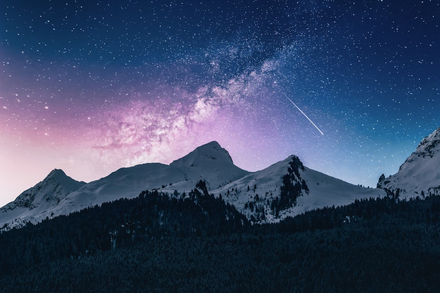 Snowy alpine mountains beneath a night sky