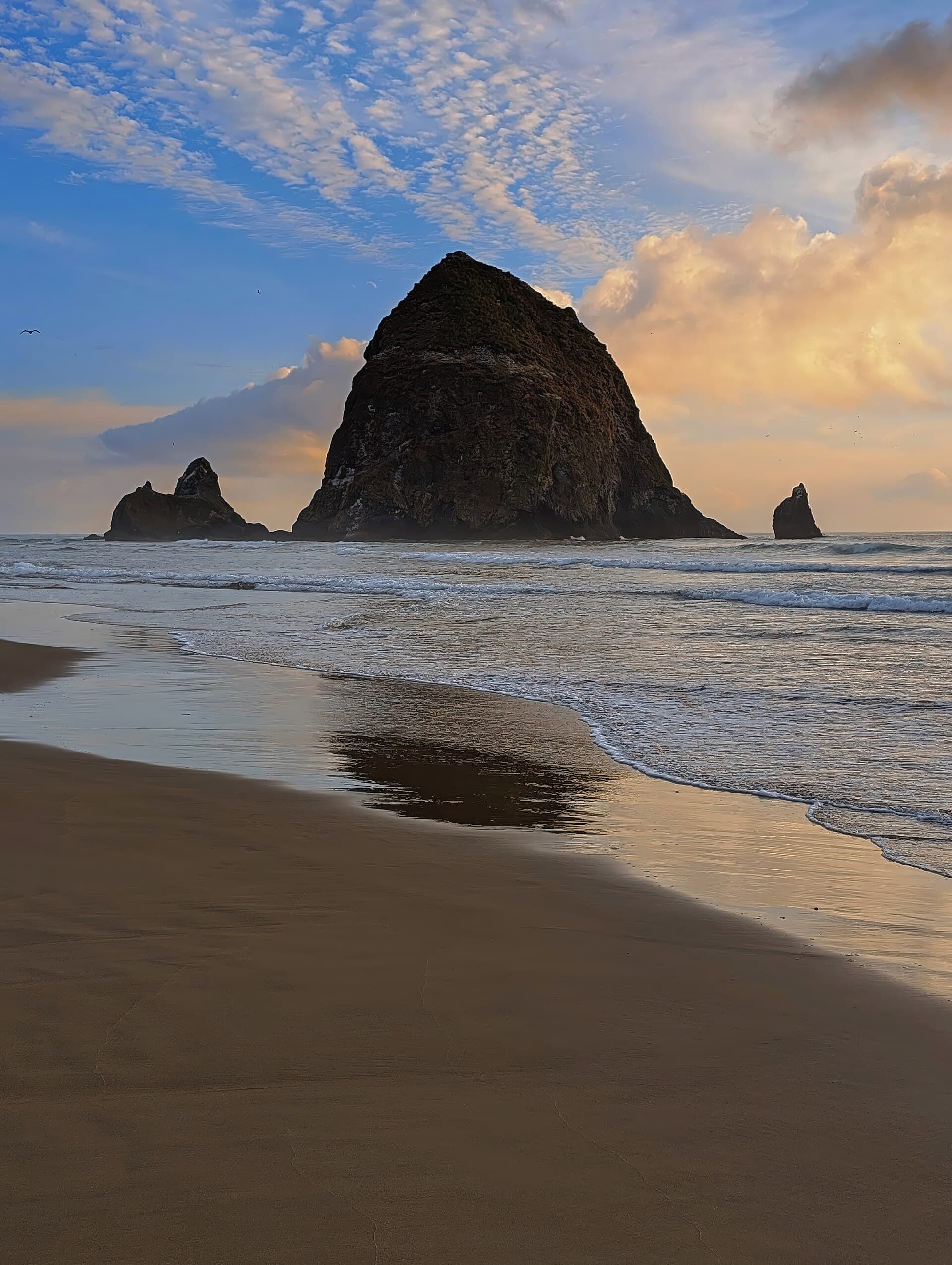Haystack Rock standing offshore at Cannon Beach under a moody sky
