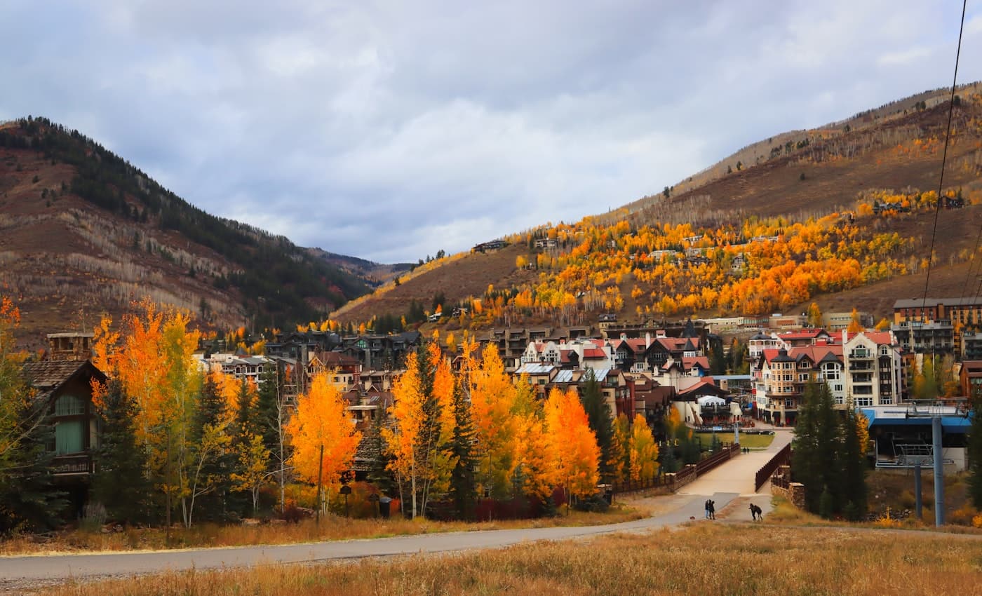 Vail village nestled in the valley beneath golden autumn aspens