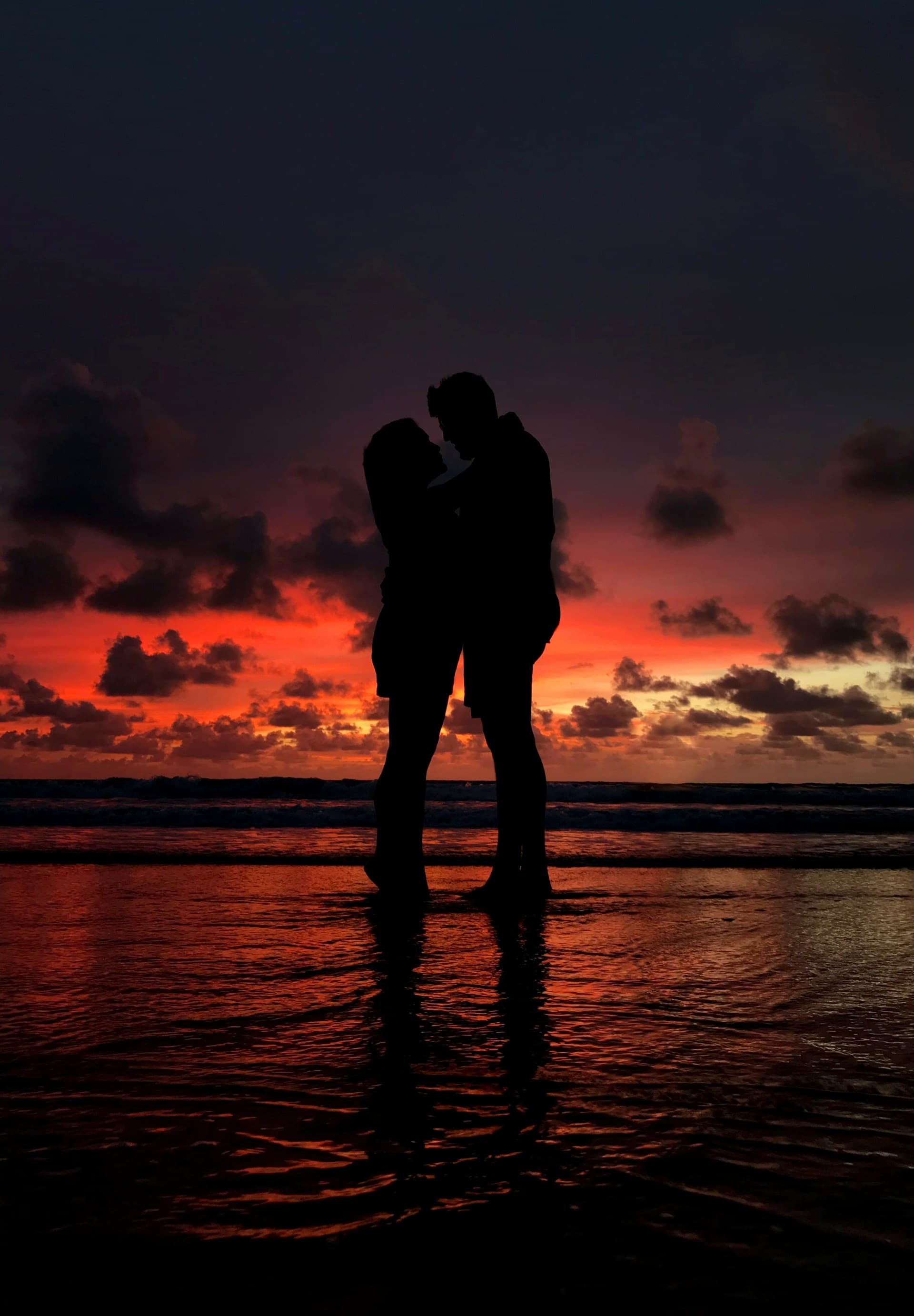 A couple on an Oregon Coast beach at golden-hour sunset