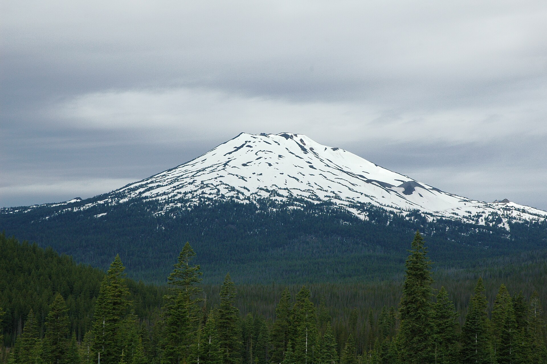A river winding through pines with snow-capped peaks beyond near Bend, Oregon