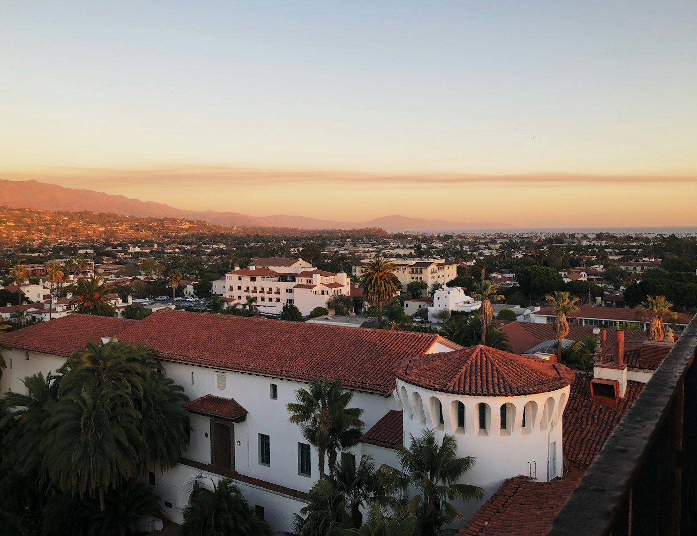 Red-tiled rooftops and palms above the coastline in Santa Barbara, California