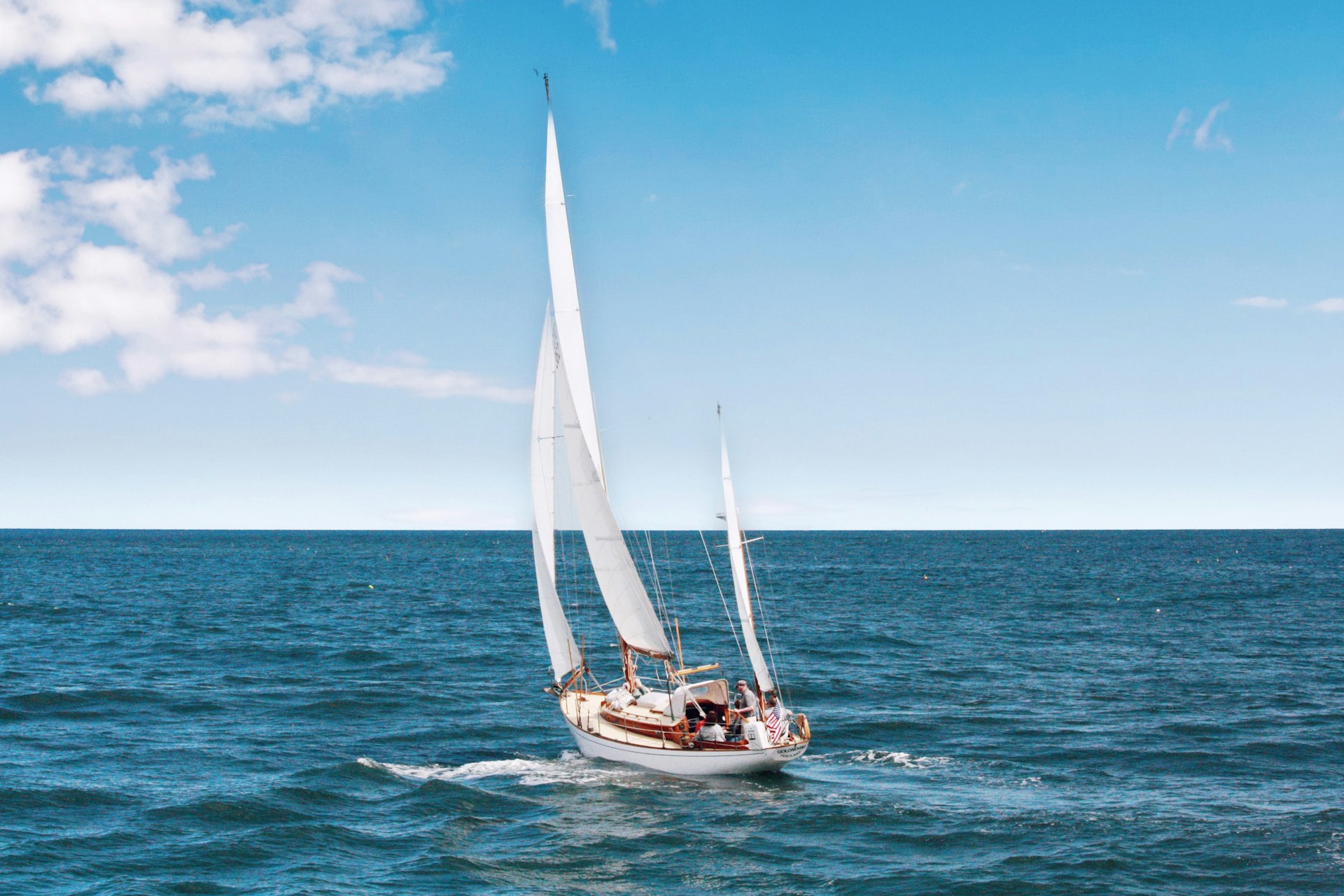 A private catamaran on turquoise water off the coast of Maui in golden light